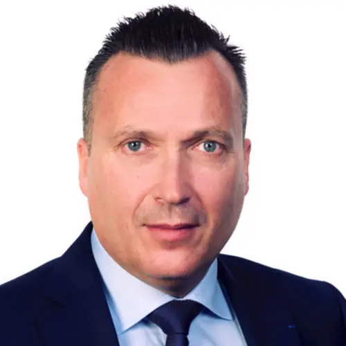 Asset manager in professional attire, posing confidently against a neutral background.
