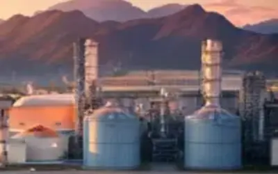 Industrial facilities against a sunset backdrop, highlighting investment opportunities in energy.