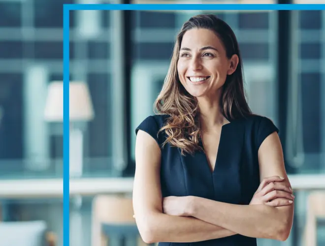 A confident asset manager stands with arms crossed in Amundi offices.