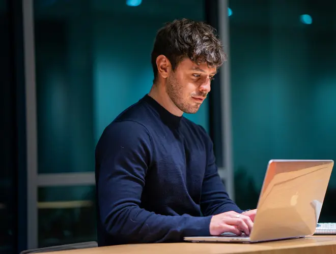 A financial expert works intently on a laptop in the Amundi offices.