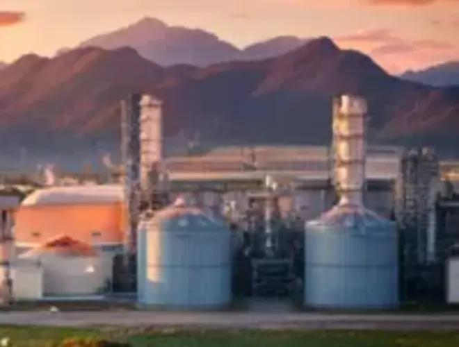 Industrial facilities against a sunset backdrop, highlighting investment opportunities in energy.