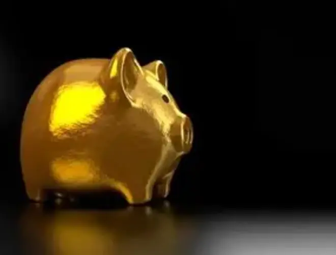 Golden piggy bank on a dark background, symbolizing savings and investment management.