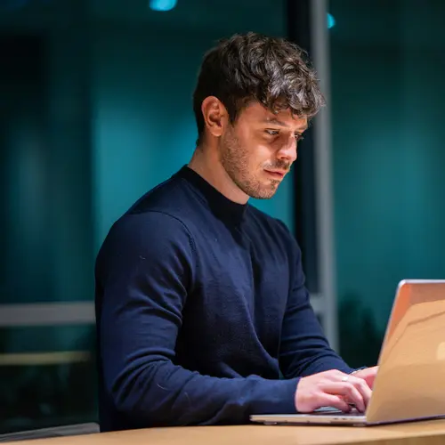A financial expert works intently on a laptop in the Amundi offices.