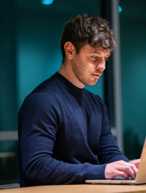 A financial expert works intently on a laptop in the Amundi offices.