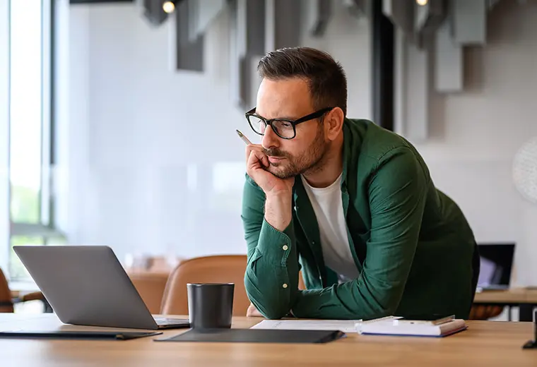 Gestore patrimoniale in ufficio Amundi, concentrato su analisi finanziaria al computer.