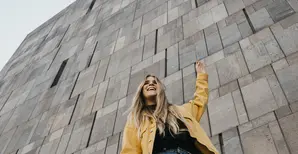 Woman in yellow jacket in front of wall