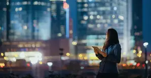 Young women holding Tablet looking at Skyline