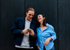 Couple leaning against wall