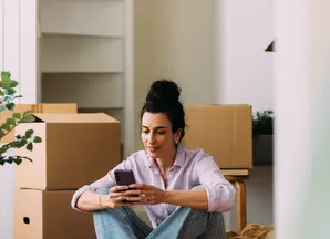 Woman sitting on floor next to cardboard boxes